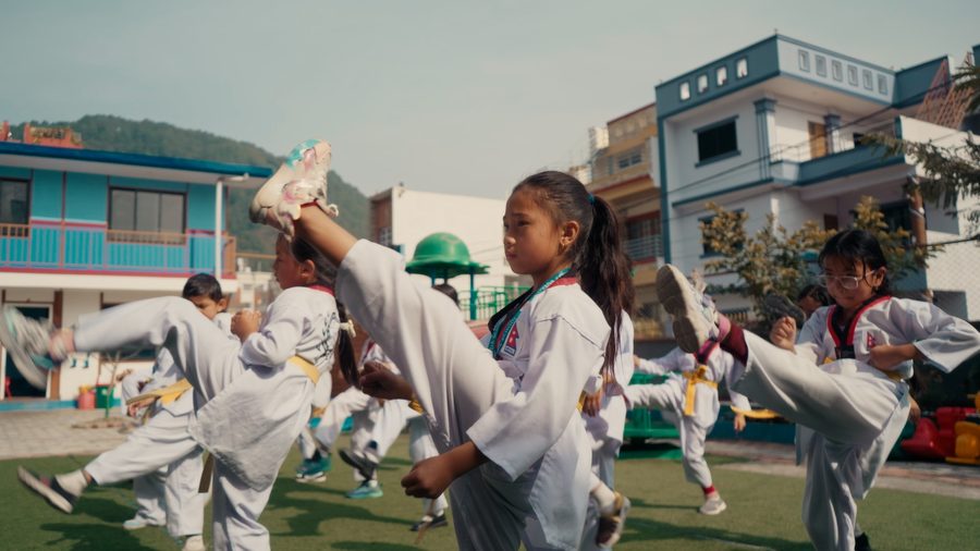 Children practising taekwondo on the school ground