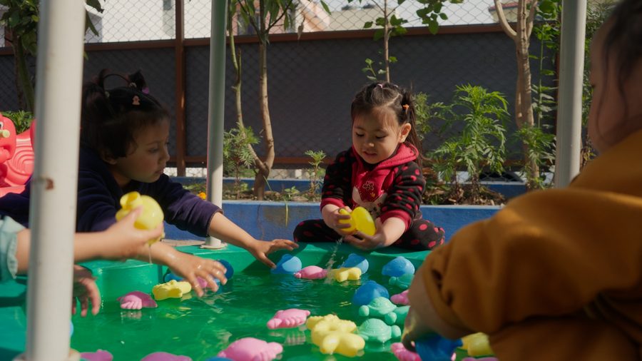 Two young children playing at a water table